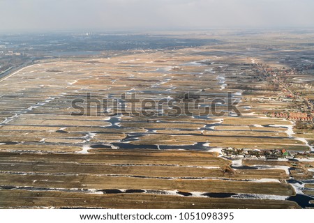 Aerial view of a nature reserve area Oostzanerpolder in Zaanstad, Holland. It is a nature reserve area with a lot of small islands which are frozen in the winter and covered by some light snowfall.