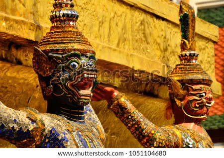 Mysterious sculptured gold statue of a sacred temple guardian in a traditional heritage royal complex in Asia for family children school holiday adventure destination