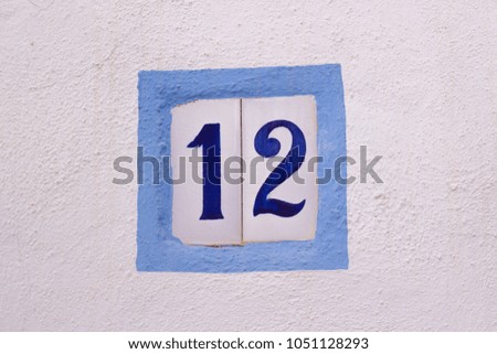 House number on ceramic tiles on white wall