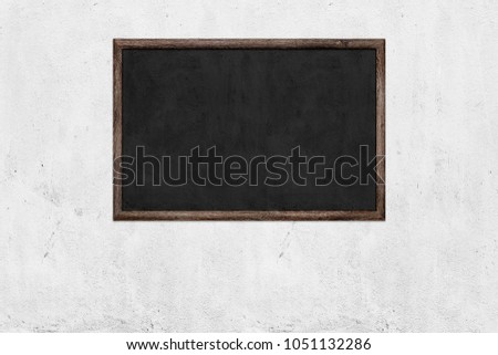 Blackboard over white concrete wall background