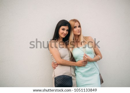 Beautiful girls posing for the photographer. Brunette and blonde is smiling