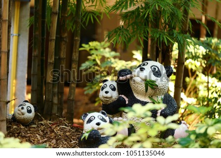 Cute panda bear statue eating leaves and bamboo tree branches