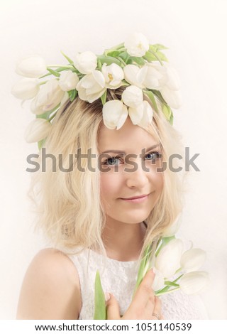 Portrait of a young woman in a wreath of flowers. Spring concept.