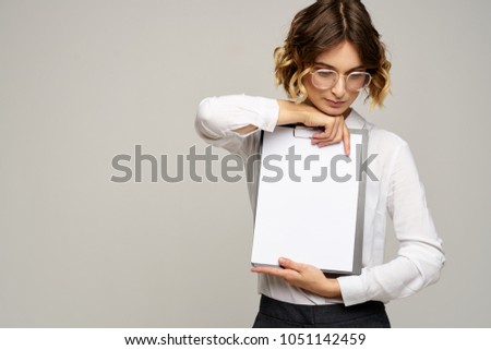  a woman in glasses holds a folder-tablet, a place to copy, business, work                              