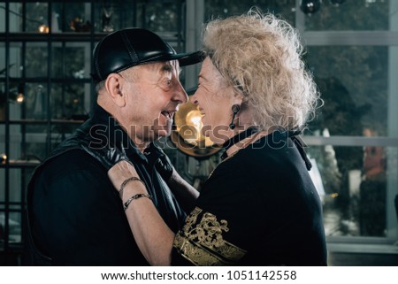 Biker grandmother and biker grandfather. Biker couple.Happy couple of retirees in biker clothes.Unusual retired couple.Merry pensioners