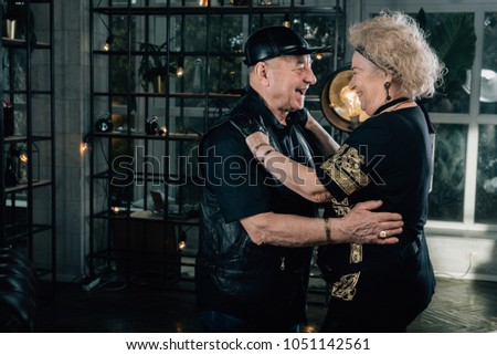 Biker grandmother and biker grandfather. Biker couple.Happy couple of retirees in biker clothes.Unusual retired couple.Happy pensioners