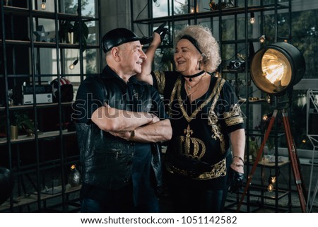 Happy couple of retirees in biker clothes.Senior motorcyclist with a black helmet and goggles looking at the camera.Unusual retired couple.Biker grandmother and biker grandfather. Biker couple.