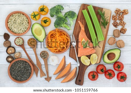 Super food to promote brain power concept with fish, vegetables, fruit, seeds, nuts and herbs on rustic wood background. Foods high in omega 3, vitamins, antioxidants and anthocyanins. Top view. Royalty-Free Stock Photo #1051159766