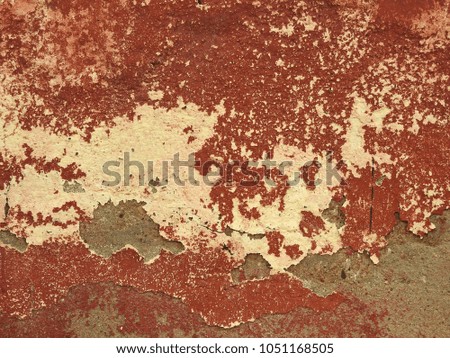 Old wall with crumbling plaster and peeling colorful layer of red-brown color. Abstract background.