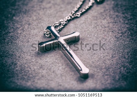 Silver cross on a gray background close up image