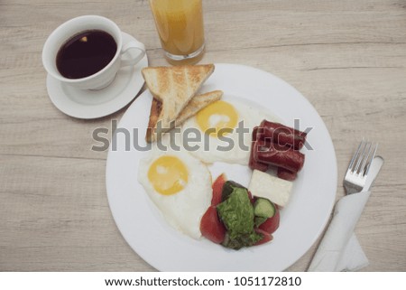 frying eggs on plate in hotel with coffee and phone