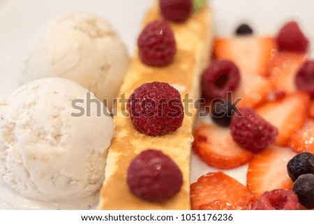 Vanilla icecream and cheese cake with raspberry, berry, strawberry and blackberry in white plate on the table with copy space.
