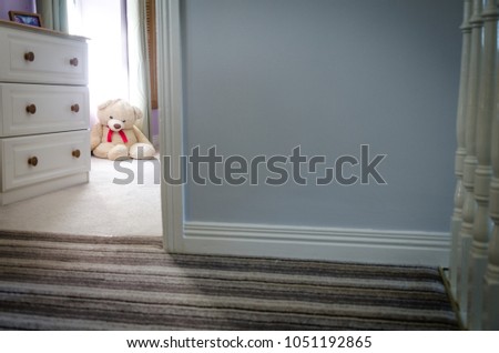 Teddy bear in bedroom looking through door