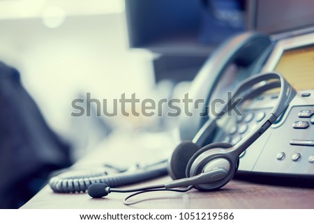 close up focus on call center headset device at telephone VOIP system at office desk for hotline telemarketing concept Royalty-Free Stock Photo #1051219586