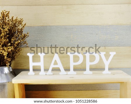 decorative letters word happy with dried flowers on wooden background