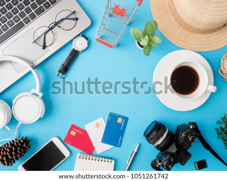 top view online shopping concept with laptop, credit card, digital camera, coffee cup, notebook and smartphone on blue table background with copy space.