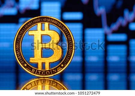 Gold coin bitcoin stacked on a bright background of business graphics close-up. Bitcoin crypto-currency. Virtual currency BTC                                       