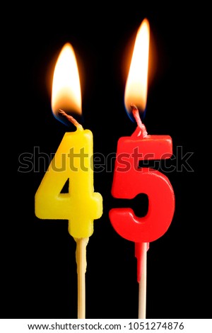 Burning candles in the form of 45 forty five figures (numbers, dates) for cake isolated on black background. The concept of celebrating a birthday, anniversary, important date, holiday, table setting
