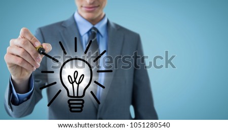 Digital composite of Business man mid section drawing light bulb doodle with flare against blue background