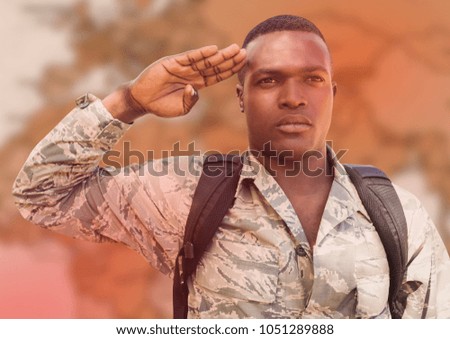 Digital composite of Soldier with backpack saluting against blurry brown map and red overlay
