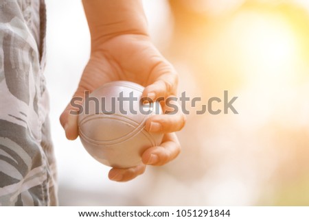 Hand of female boule holding boule or petanque ball on match Royalty-Free Stock Photo #1051291844