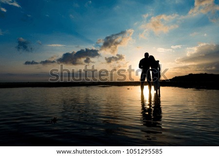 silhouette of a hugging couple against the background of the rising sun of Bali island