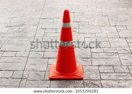 Traffic cone on stone tiles road.