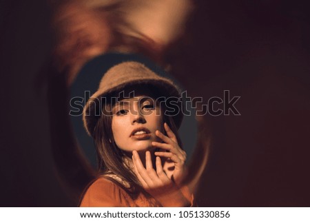 portrait of fashionable woman in hat looking at camera