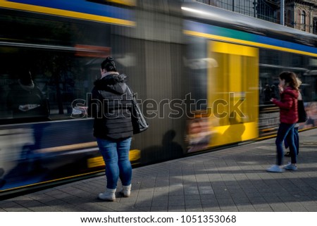 Passengers at the tram stop.
Passengers are waiting to take off to the tram that arrives at the stop, blurred tram in the background.
 Royalty-Free Stock Photo #1051353068