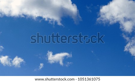 White fluffy clouds against a blue sky, background

