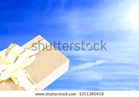 clear sunny day. the sky is blue. gift box in old style, with a gold ribbon.