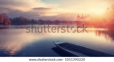 Wonderful Autumn Landscape. Famouse Moritzburg Castle near Dresden under sunlit. with colorful sky  over the Lake, Awesome artistic Picture. Amazing Picturesque Scene. Creative image. Postcard