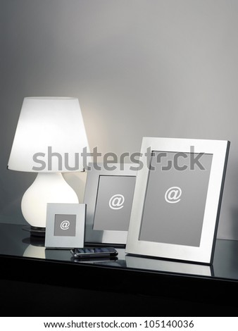 Metal Frames with smartphone and a white light on a black glass top
