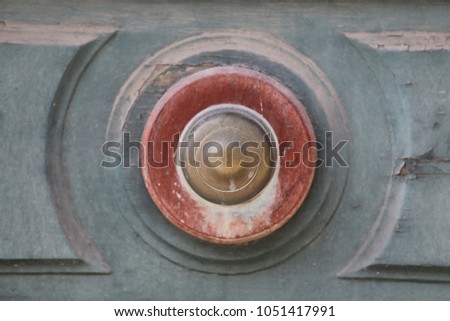 Close up outdoor view of a door handle. Golden round element fixed at a blue wooden ancient door. Geometric forms with circles, lines and mouldings. Architectural abstract image. Vintage design.
