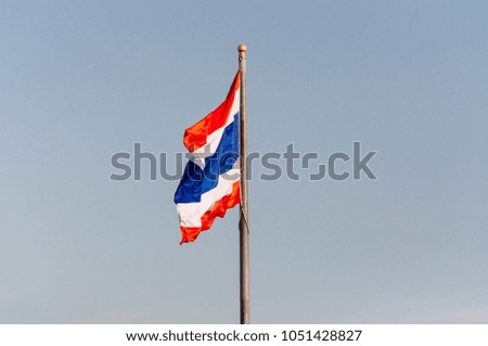Image of waving Thai flag of Thailand with blue sky background , Thai flag