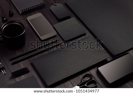 Blank black corporate stationery on dark stylish wood background, inclined. Branding mock up for branding, graphic designers presentations and business portfolios. Modern stylish work place.