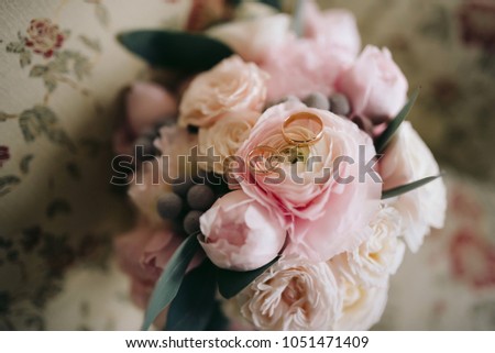 Wedding rings on a bouquet of pink roses