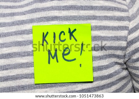Sticky note with word "Kick me" on man's back, closeup. 1st April prank.