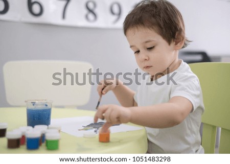 A cute, mixed-race toddler boy is drawing and being creative.
