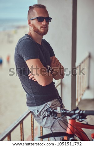 A handsome redhead male with a stylish haircut and beard dressed