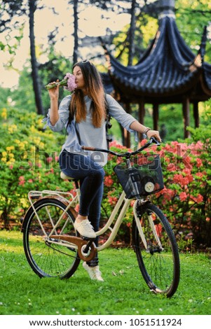 Portrait of attractive brunette with city bicycle near tradition