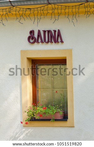 Sauna sign outdoor on building wall with window