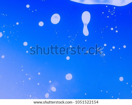 The abstract background with paints on a glass .