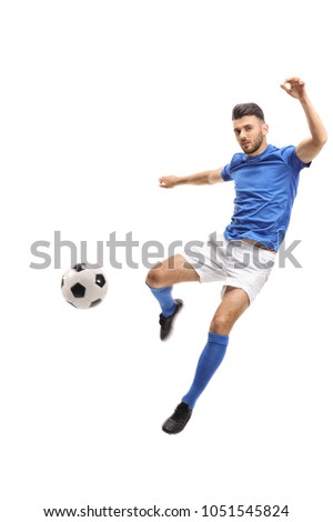 Male soccer player kicking a football in mid-air isolated on white background