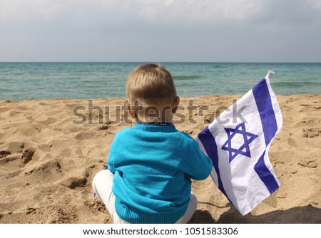 boy with the flag of Israel on the beach