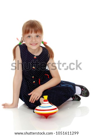 Little girl playing with a whirligig. Isolated on white background.