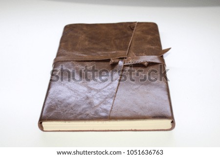 Brown leather notebook over white background
