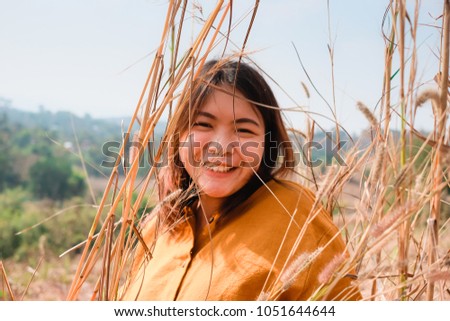 Young Asian woman feeling happy and relax in the field.
