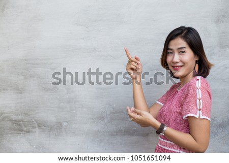 The cute Asian woman are thinking something on gray background