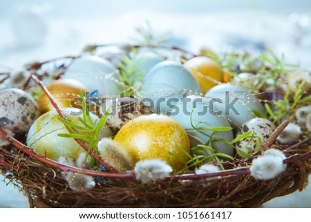 Easter background with Easter blue and gold eggs, pussy-willow and spring flowers. Top view with copy space Royalty-Free Stock Photo #1051661417
